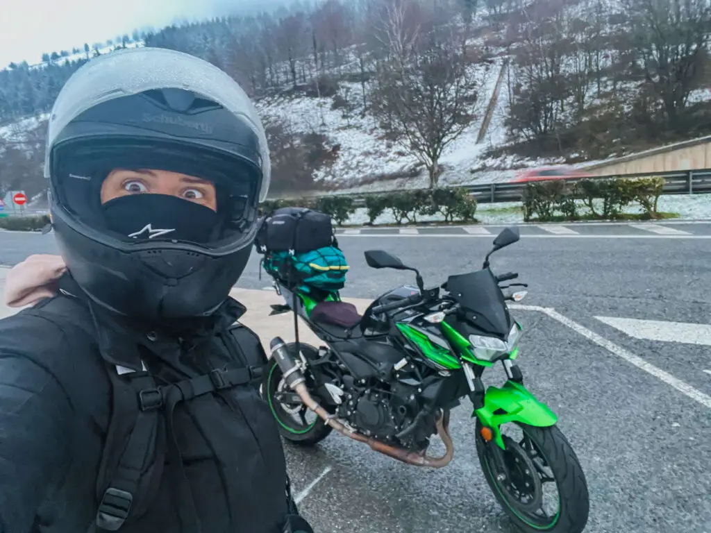 girl in snow touring europe on a motorbike